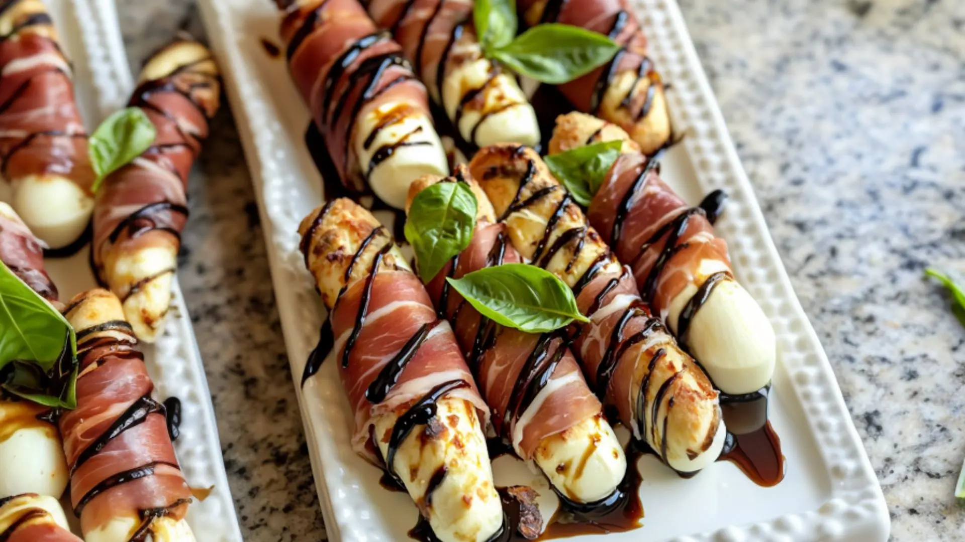 Mozzarella wrapped with prosciutto appetizer on granite countertop