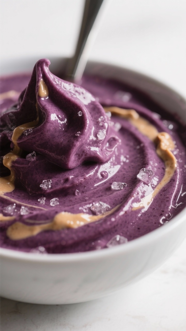 Close-up detail: Thick, soft-serve–like acai smoothie base just finished blending in a chilled bow